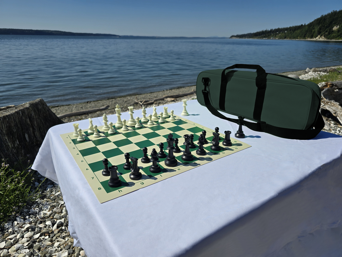 Tournament Chess Set on a Vinyl Chess Board with Deluxe Carrying Bag on a White Cloth Table on the Beach