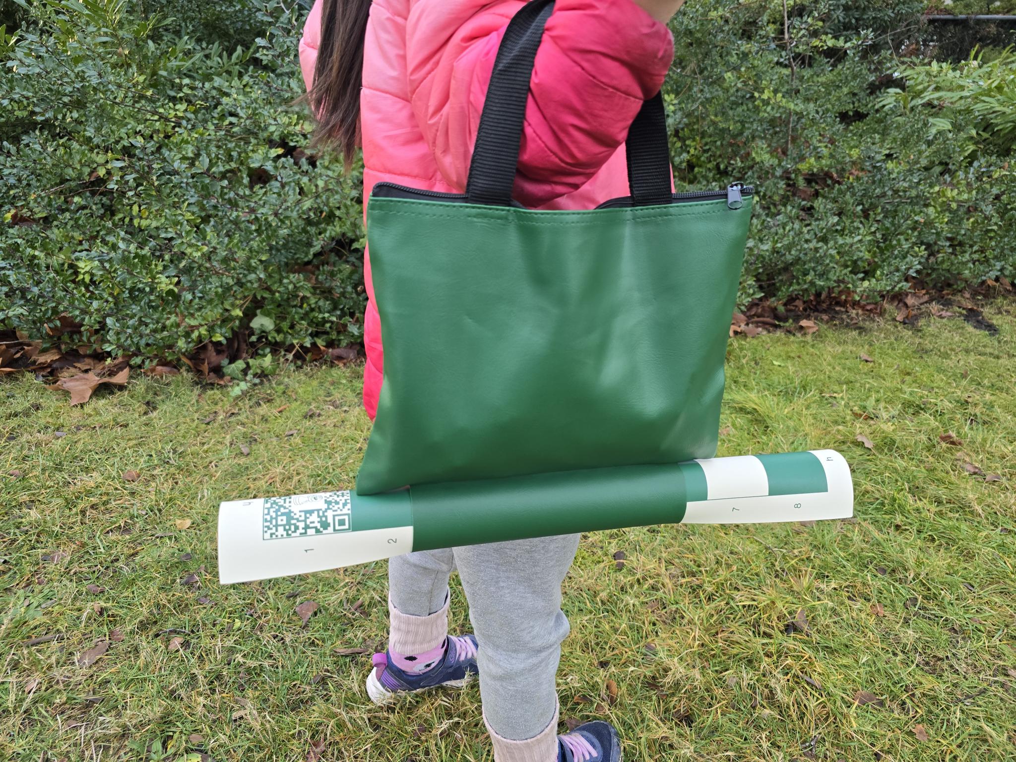 ChessKid Tote Chess Set with Vinyl Chess Board in Protective Sleeve Carried by a Young Child (Side Profile)