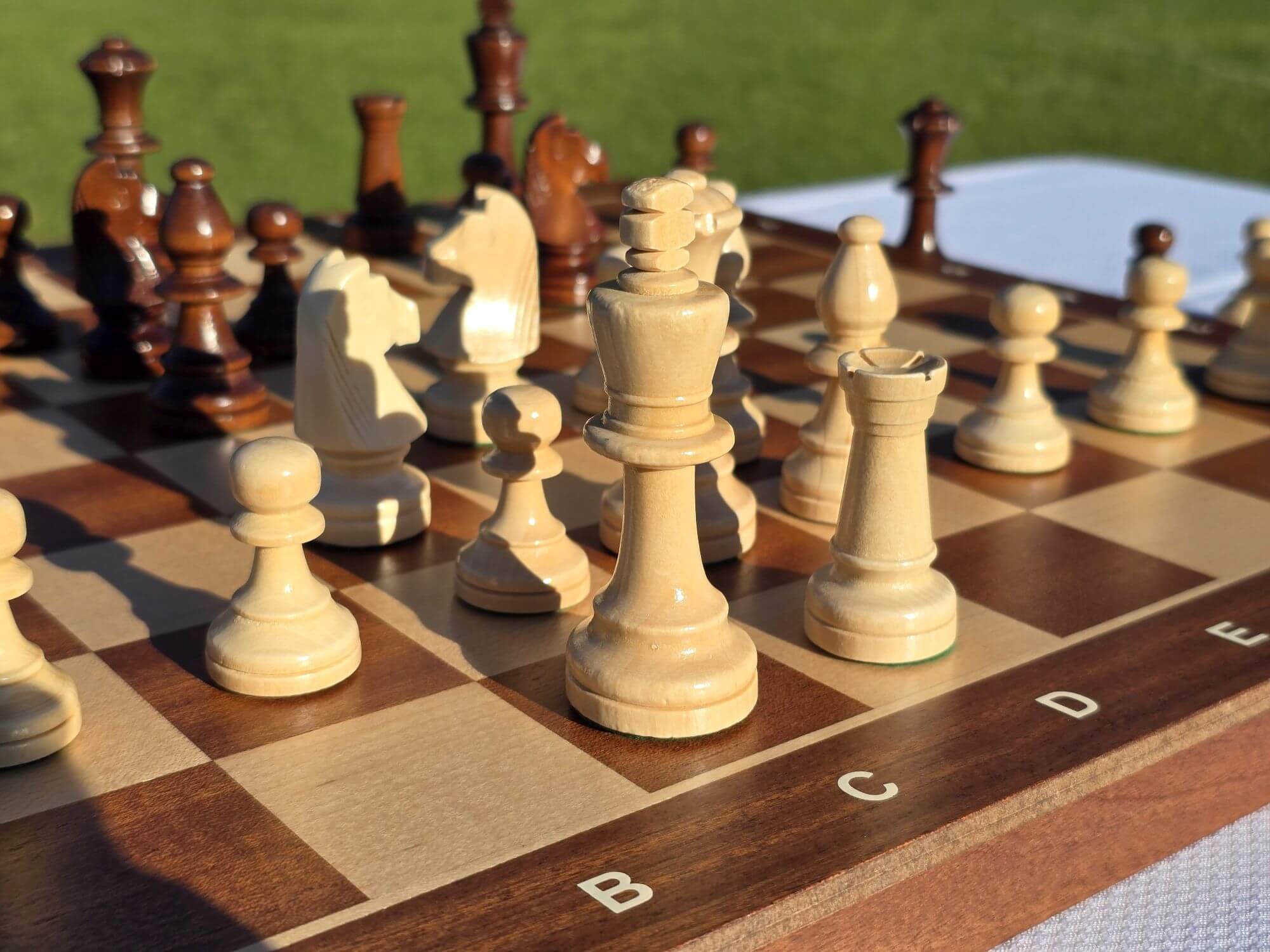 Close-up details of the white wooden king, queen, and bishops on the Aristocrat folding chess board.