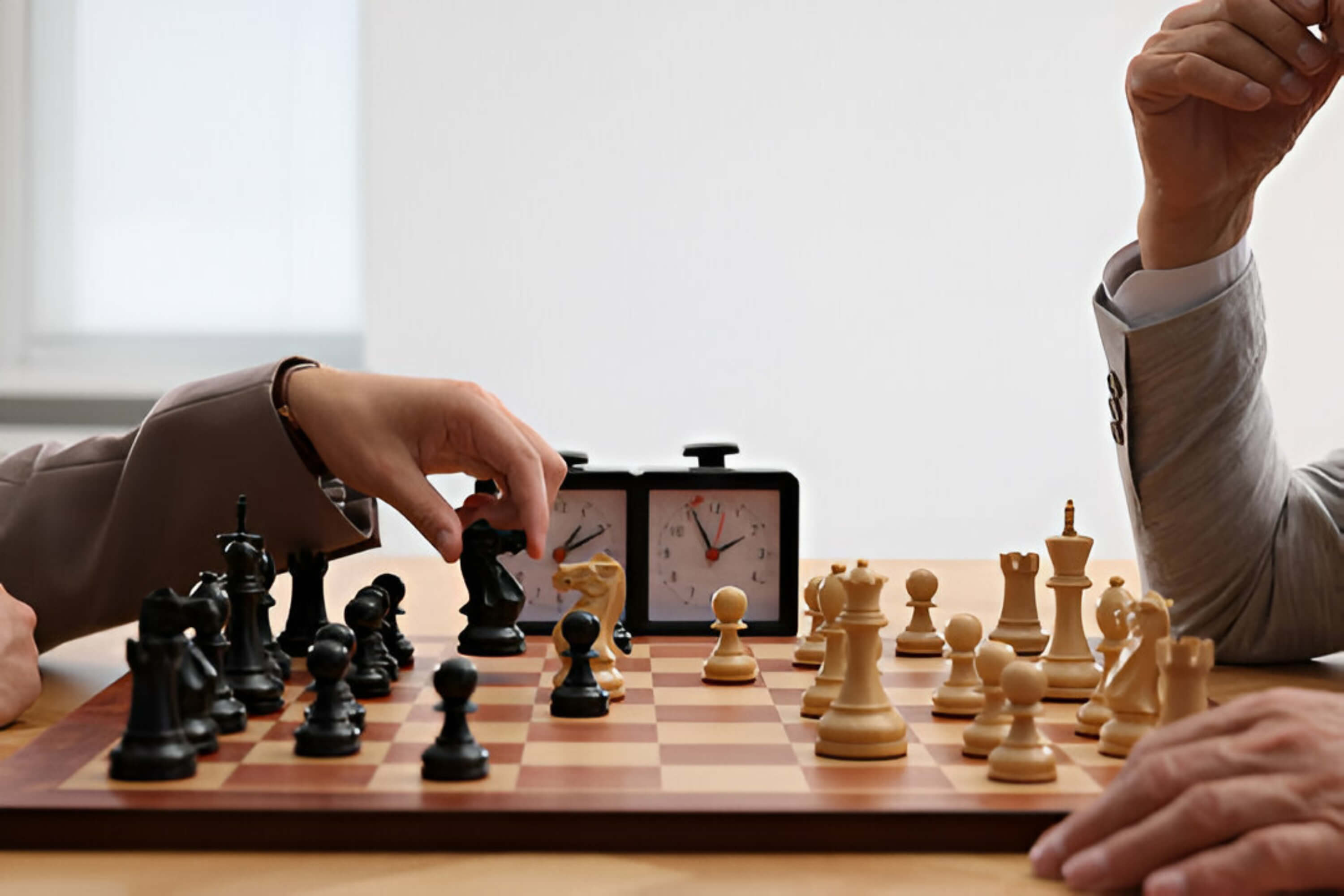 Wooden Chess Set and a Vintage Clock with Two Players Arms in the Scene