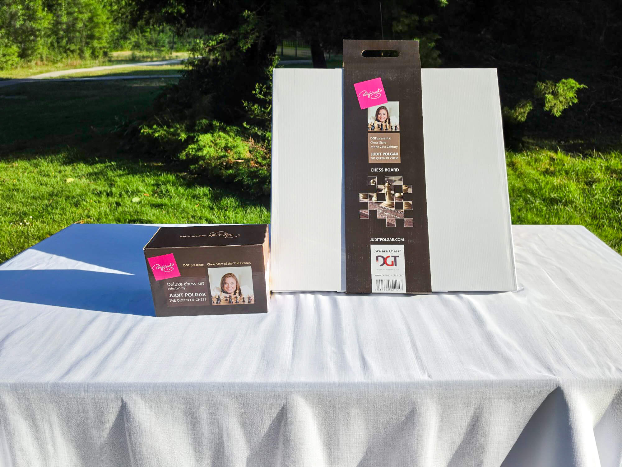 Outdoor display of the Judit Polgar chess set packaging and presentation box on a white table.