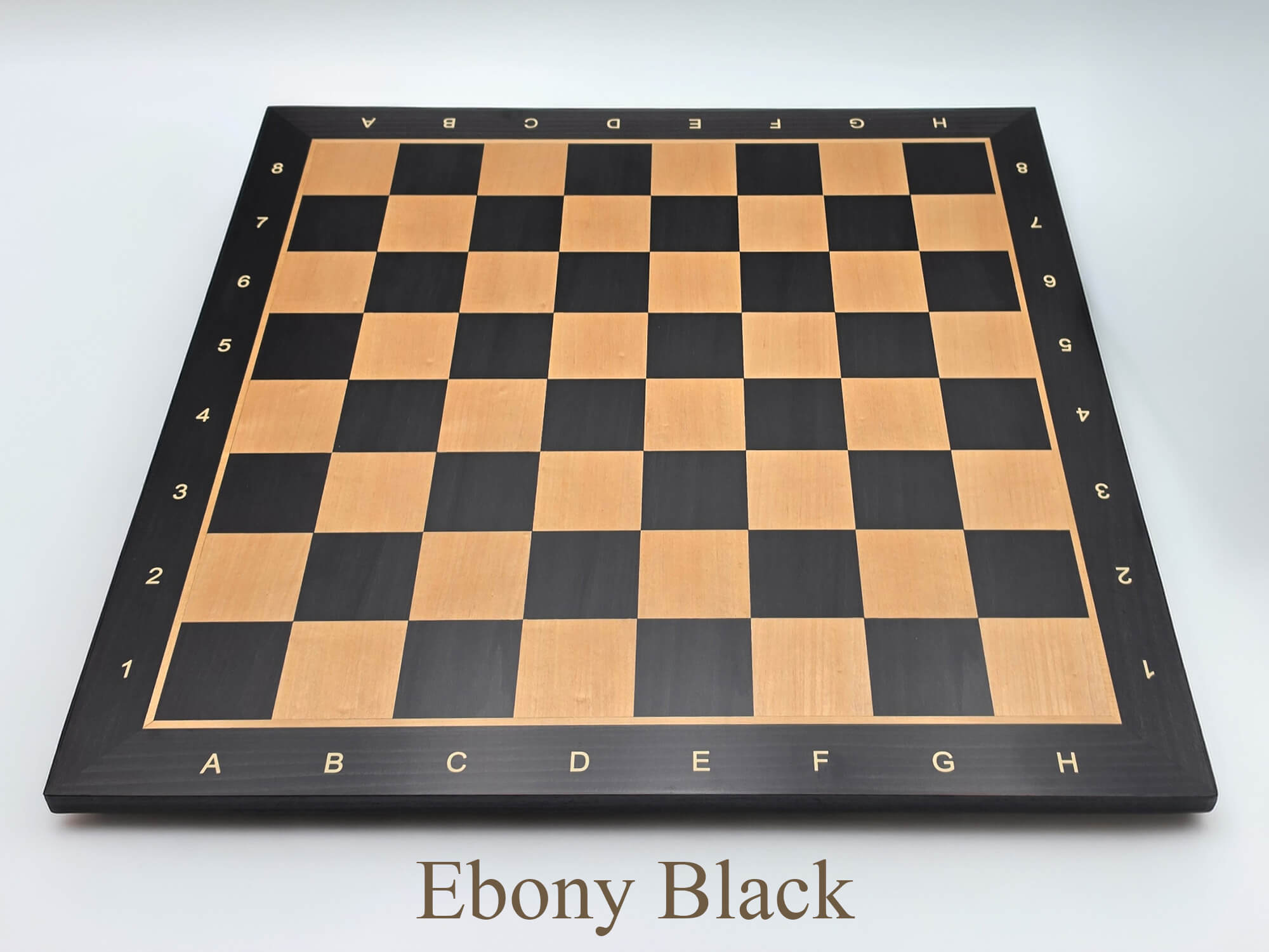 Top-down view of the stunning Monarch Series engineered ebony and maple chess board, featuring high-contrast 57mm squares and clear algebraic notation.