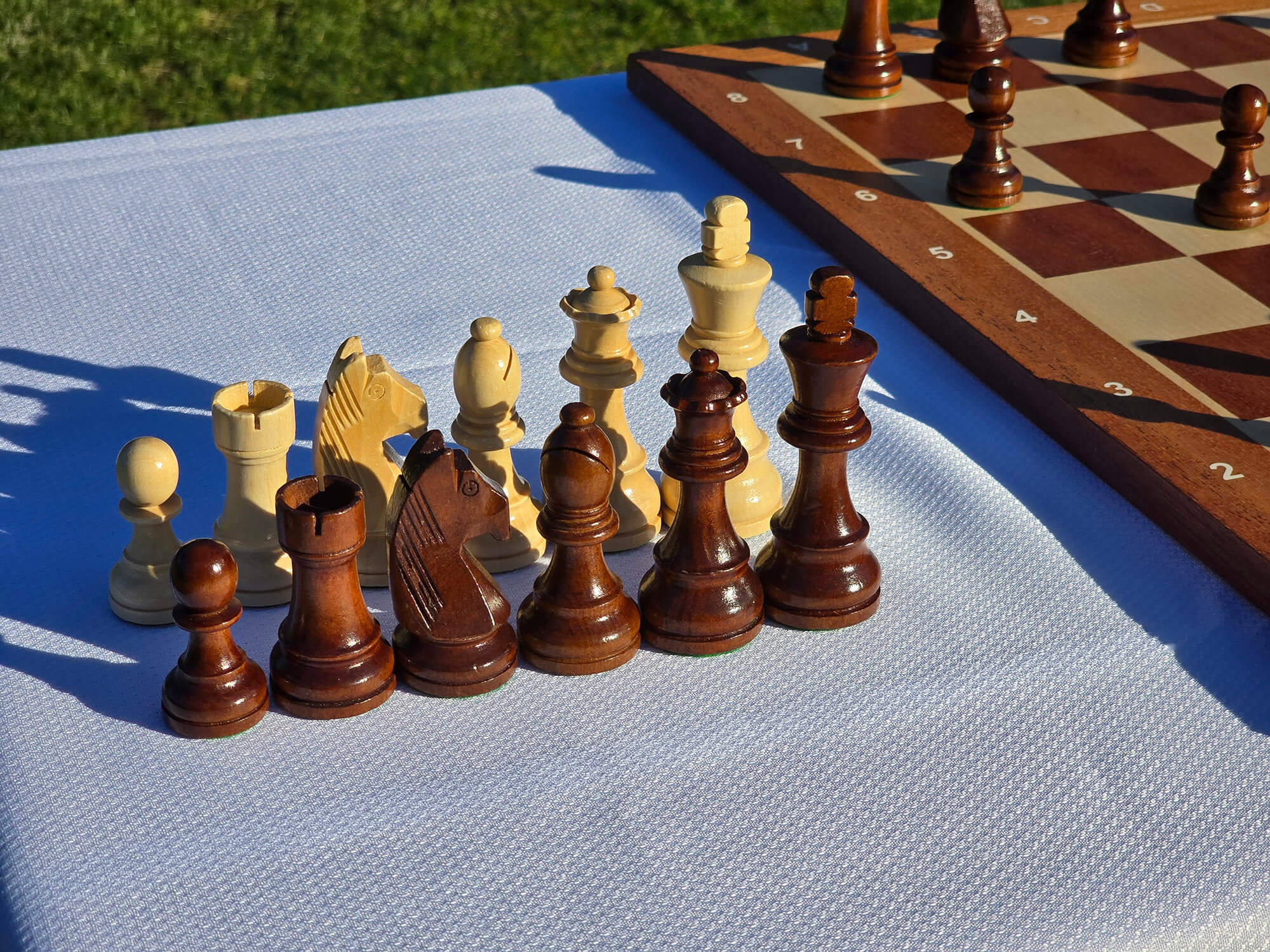 A complete set of handcrafted Monarch wooden chess pieces displayed together.