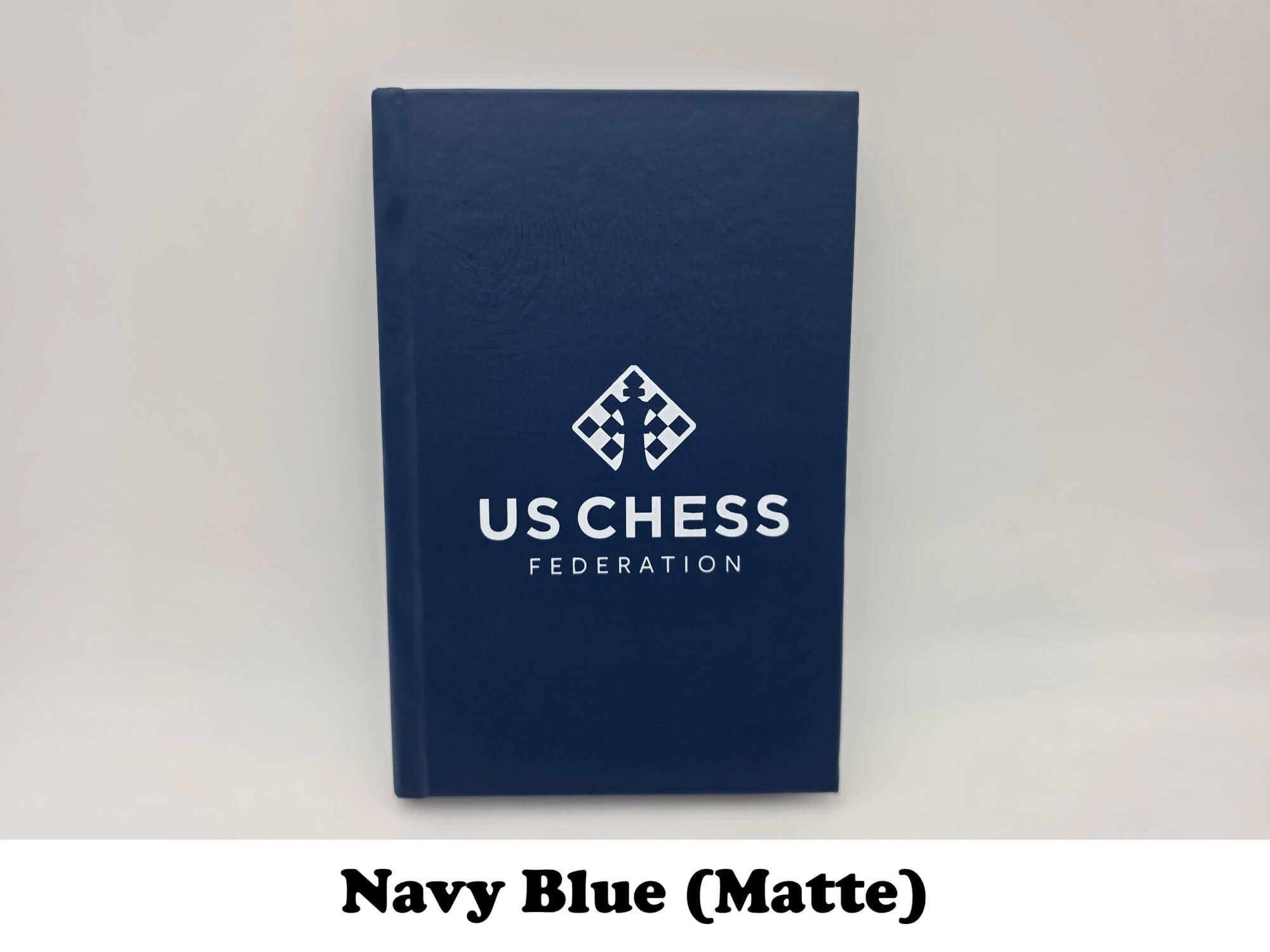 Matte navy blue USCF chess notation record book.