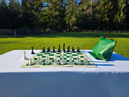 ChessKid Tote Chess Set with Vinyl Chess Board on White Cloth Table in Park (Under Shining Sun, Straight-On Shot)
