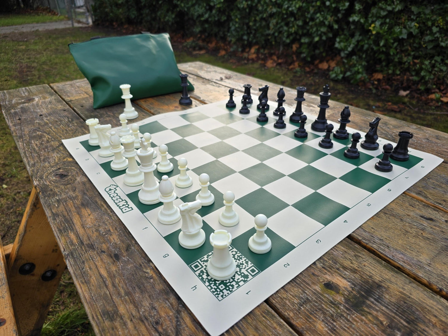 ChessKid Tote Chess Set with Vinyl Chess Board on Park Bench (Angled Shot from White&