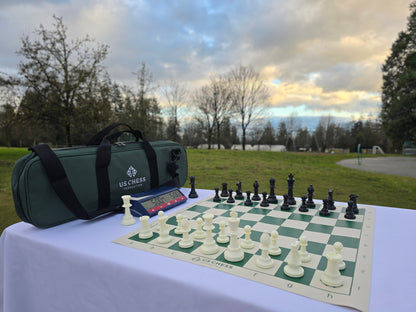 USCF Deluxe Chess Set with Vinyl Chess Board and DGT North American Chess Clock 2024 in Park Against a Beautiful, Golden Cloud and Blue Sky Background