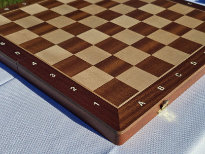 High-angle side view of the empty Aristocrat folding wooden chess board showcasing the alphanumeric coordinates and grain.