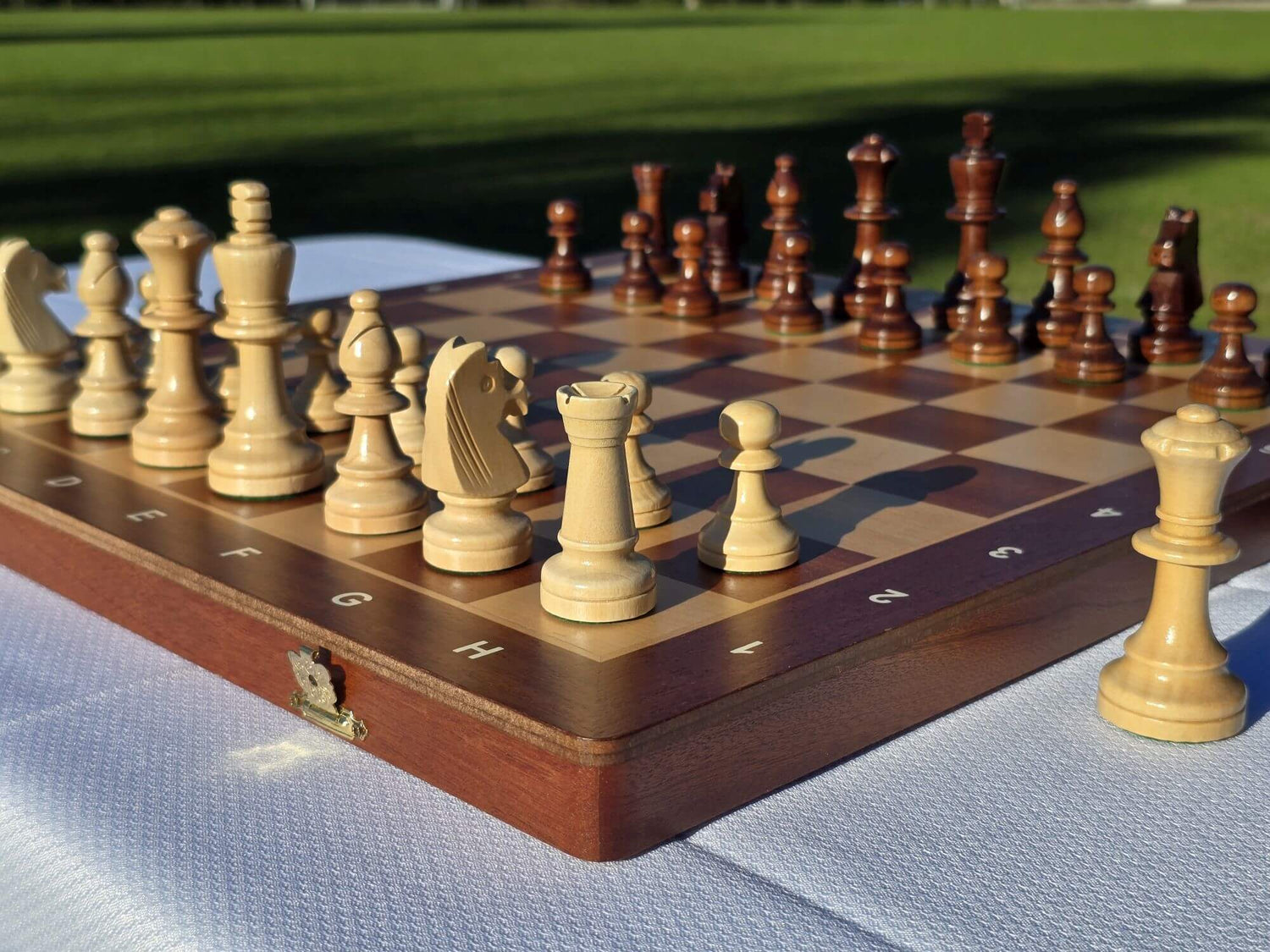 Full perspective view of the Aristocrat folding wooden chess set with pieces set up on a sunny day.