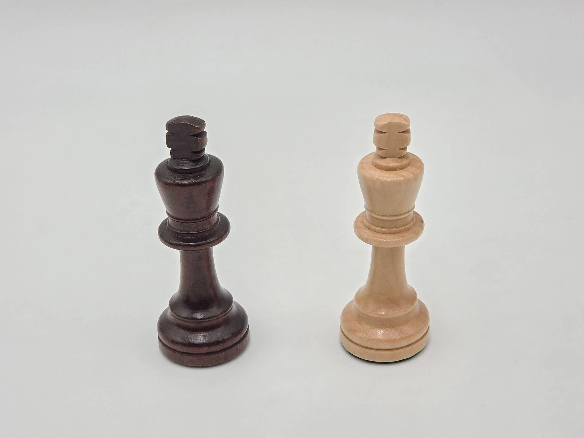 Side-by-side product shot of the dark and light wooden king pieces from the Aristocrat chess set on a white background.