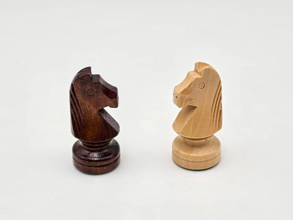 Studio display of the intricately carved dark and light wooden knight pieces from the Aristocrat collection.