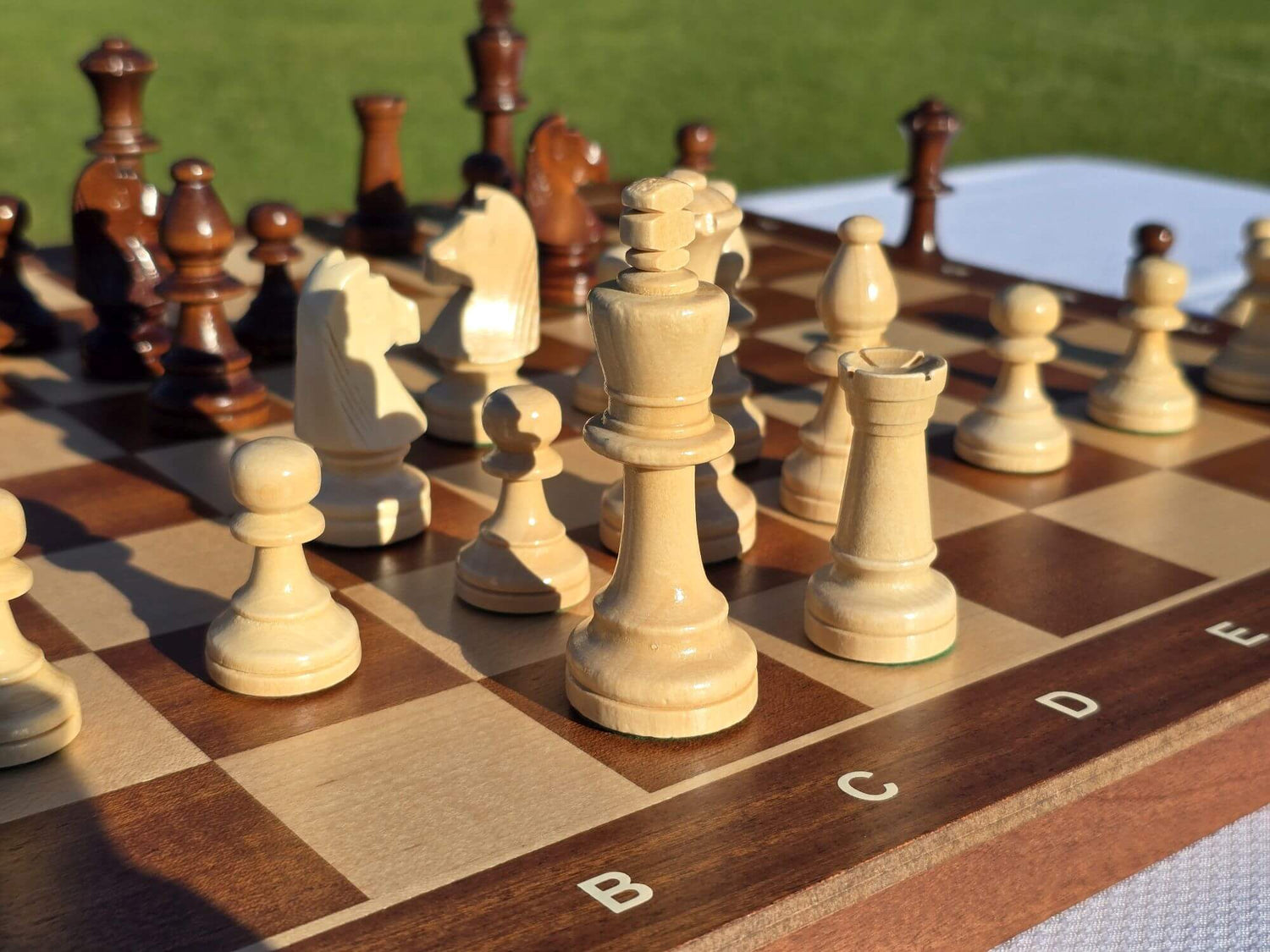 Close-up details of the white wooden king, queen, and bishops on the Aristocrat folding chess board.