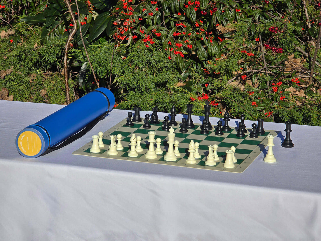 Blue Sentry telescopic chess tube with a roll-up vinyl board and Staunton pieces on a white tablecloth.