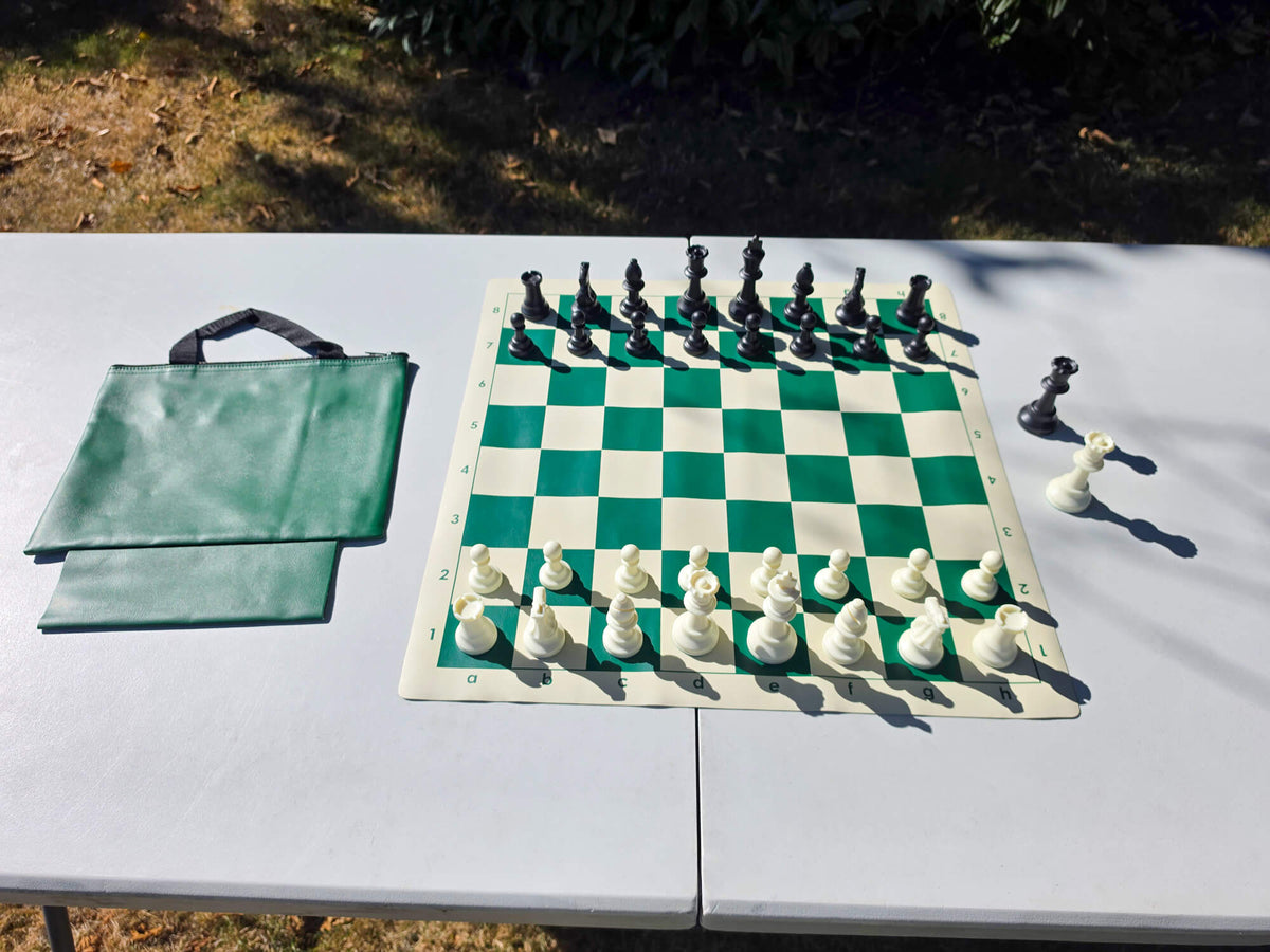 Campaigner Tournament chess set featuring a green roll-up vinyl board, plastic Staunton pieces set up, and matching green zippered tote bag.