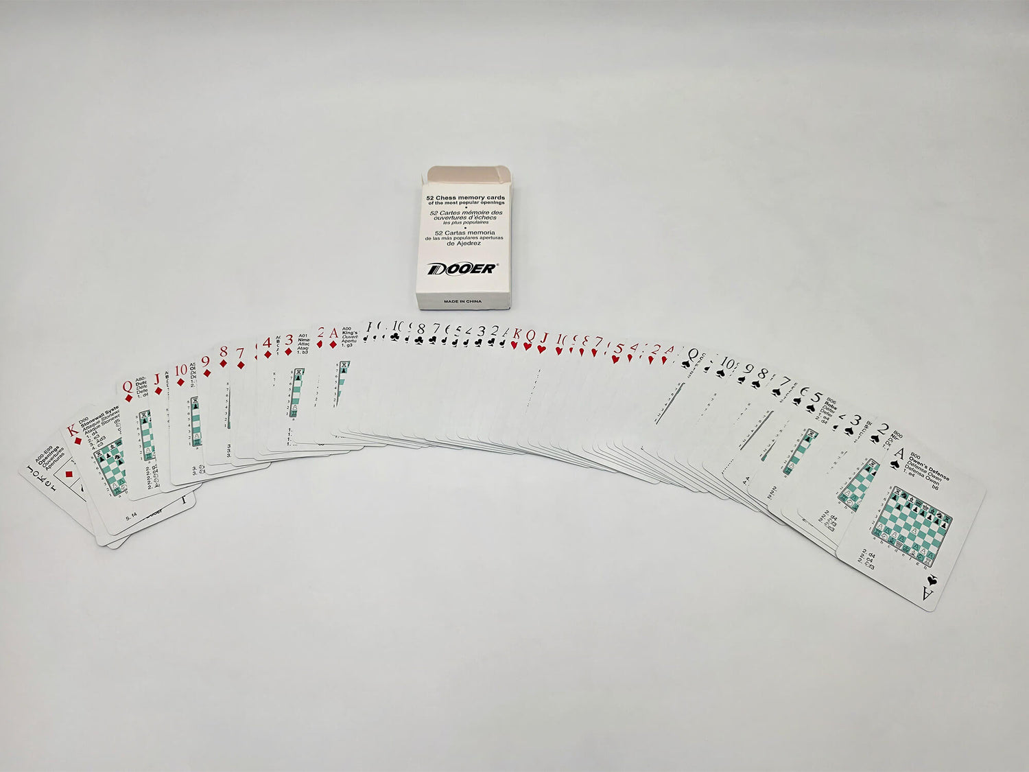Fanned-out deck of 52 chess opening flashcards showing move notations next to the original box