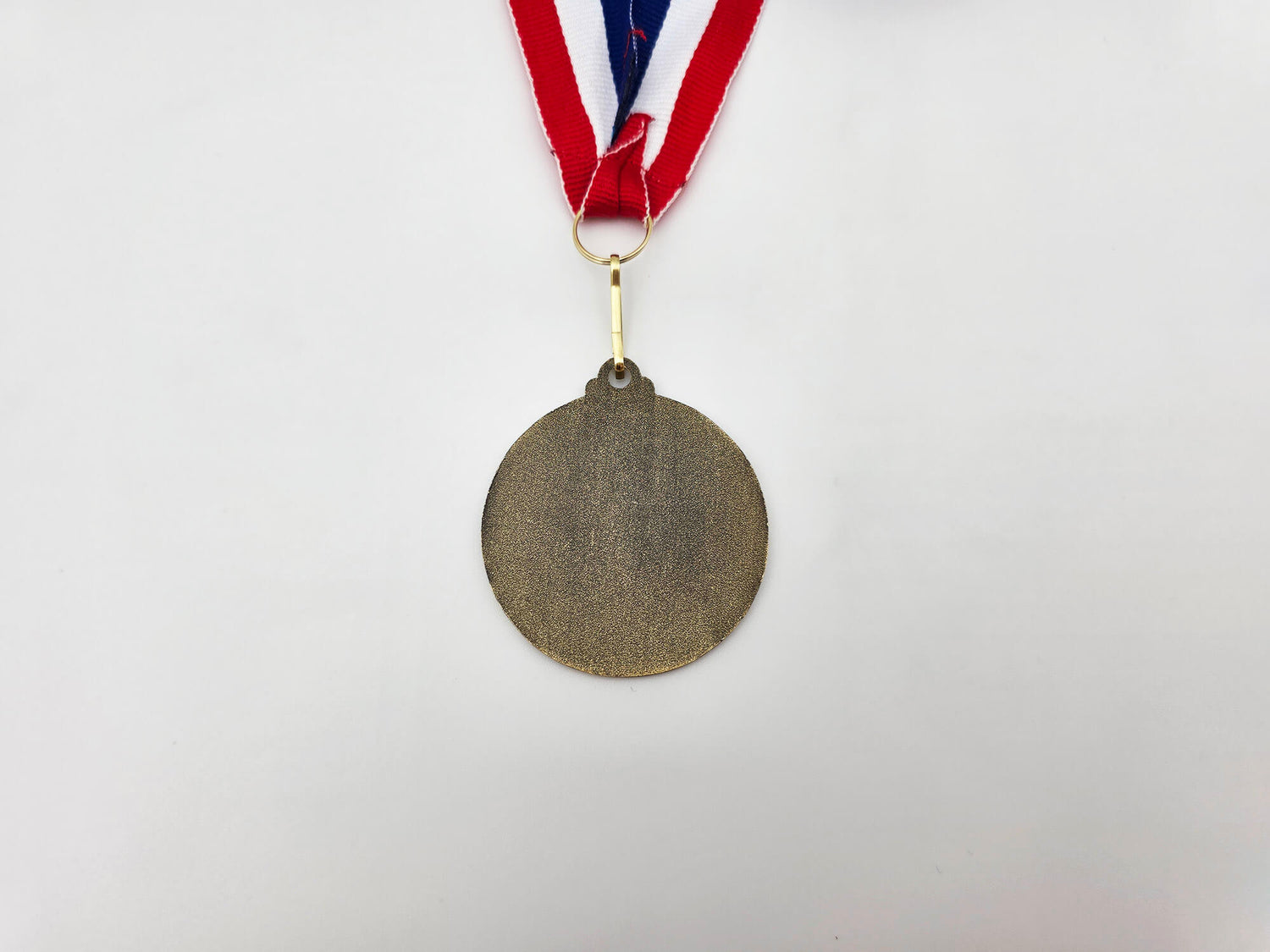 The smooth, polished gold back of the Classic Emblem medal, designed for custom engraving and personalized awards.
