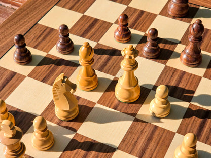 Perspective shot from above the dark pieces showing DGT Timeless wooden chess pieces spread across a board in a playing position.