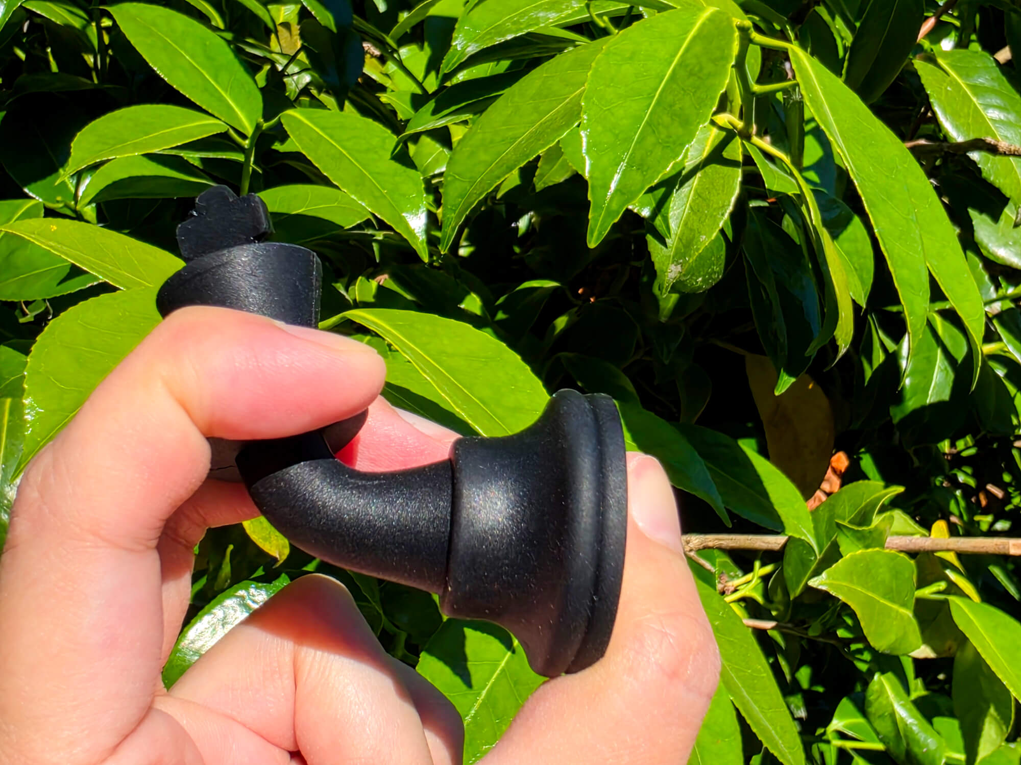 Hand squishing and bending a flexible, durable black silicone chess piece to show elasticity.