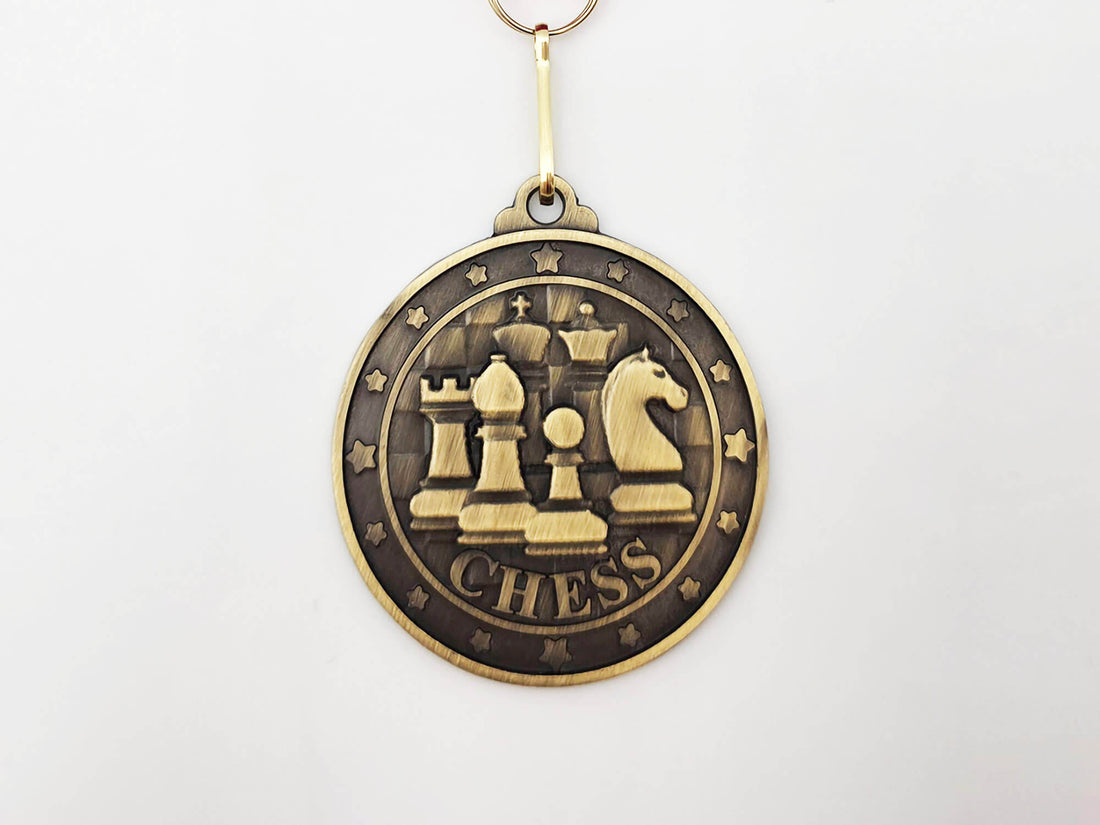 Macro shot of the Classic Emblem gold medal showing the intricate 3D relief of chess icons and a textured border.