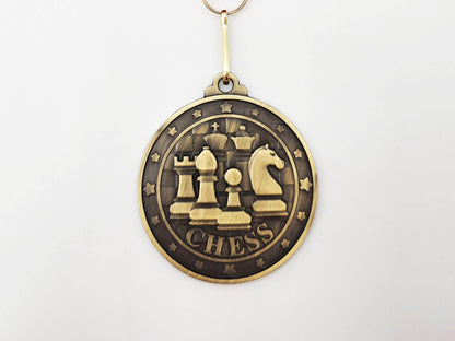 Macro shot of the Classic Emblem gold medal showing the intricate 3D relief of chess icons and a textured border.