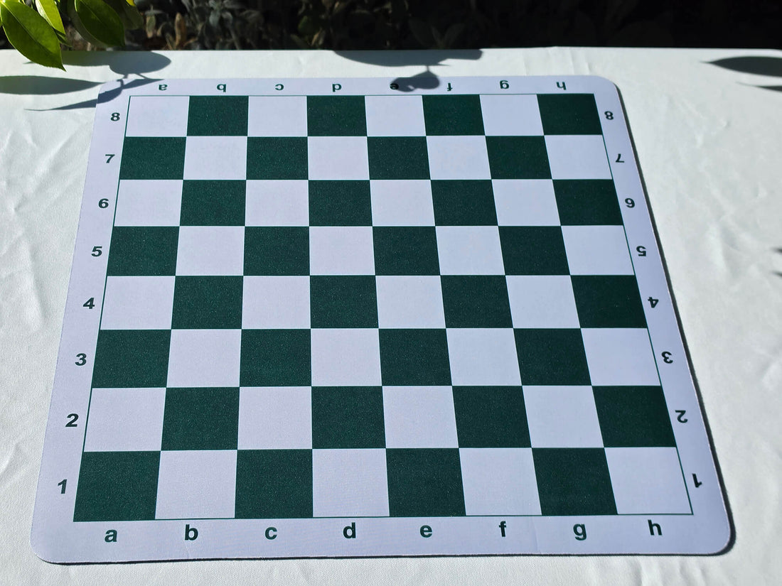 Full top-down view of an empty green and white tournament mousepad chess board with clear algebraic notation borders.