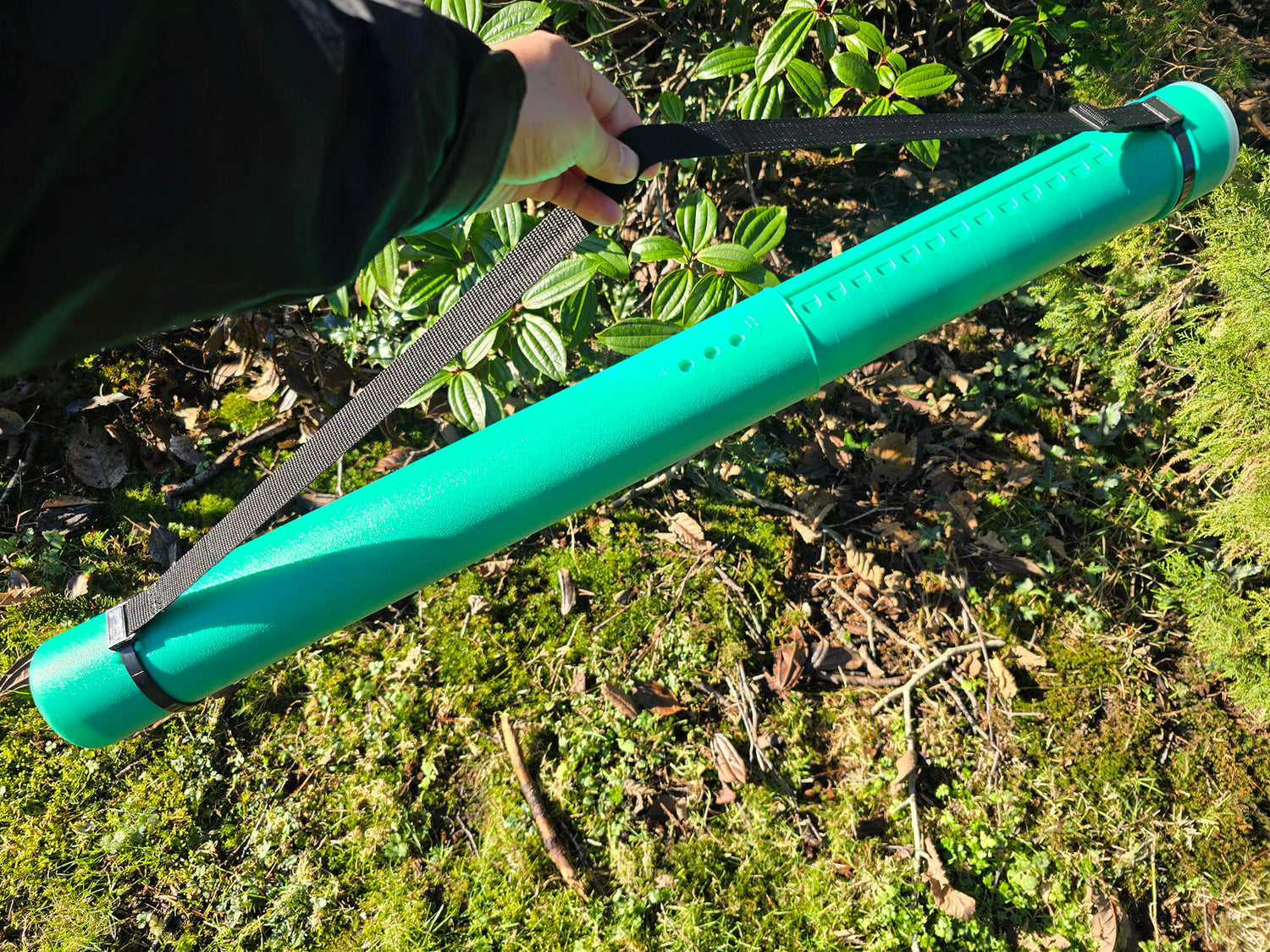 A close-up of the green Sentry telescopic chess tube fully extended to fit larger boards and pieces.