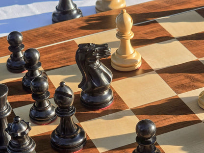 Close-up perspective shot of a black knight piece on a wooden chessboard.