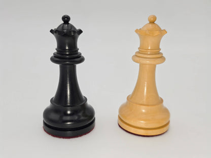 Black and natural wood Judit Polgar chess set queens standing side by side against a white background.