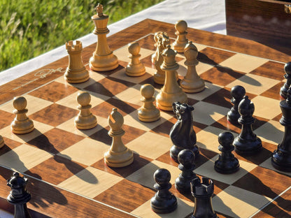 Outdoor perspective view of Judit Polgar wooden chess pieces setup on a board in sunlight.