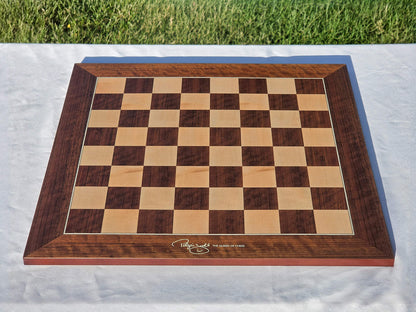 High-angle shot of the official Judit Polgar wooden chessboard set up on a white table.