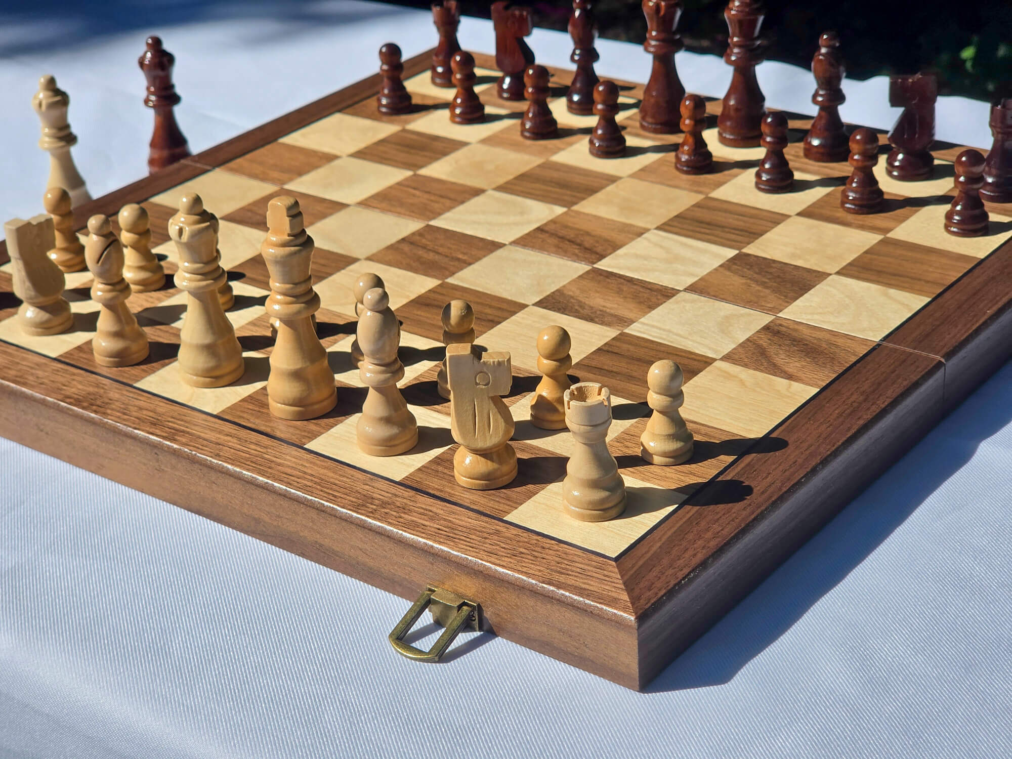Angled close-up of the Marquis Magnetic Walnut Chess Set fully set up with pieces in starting position