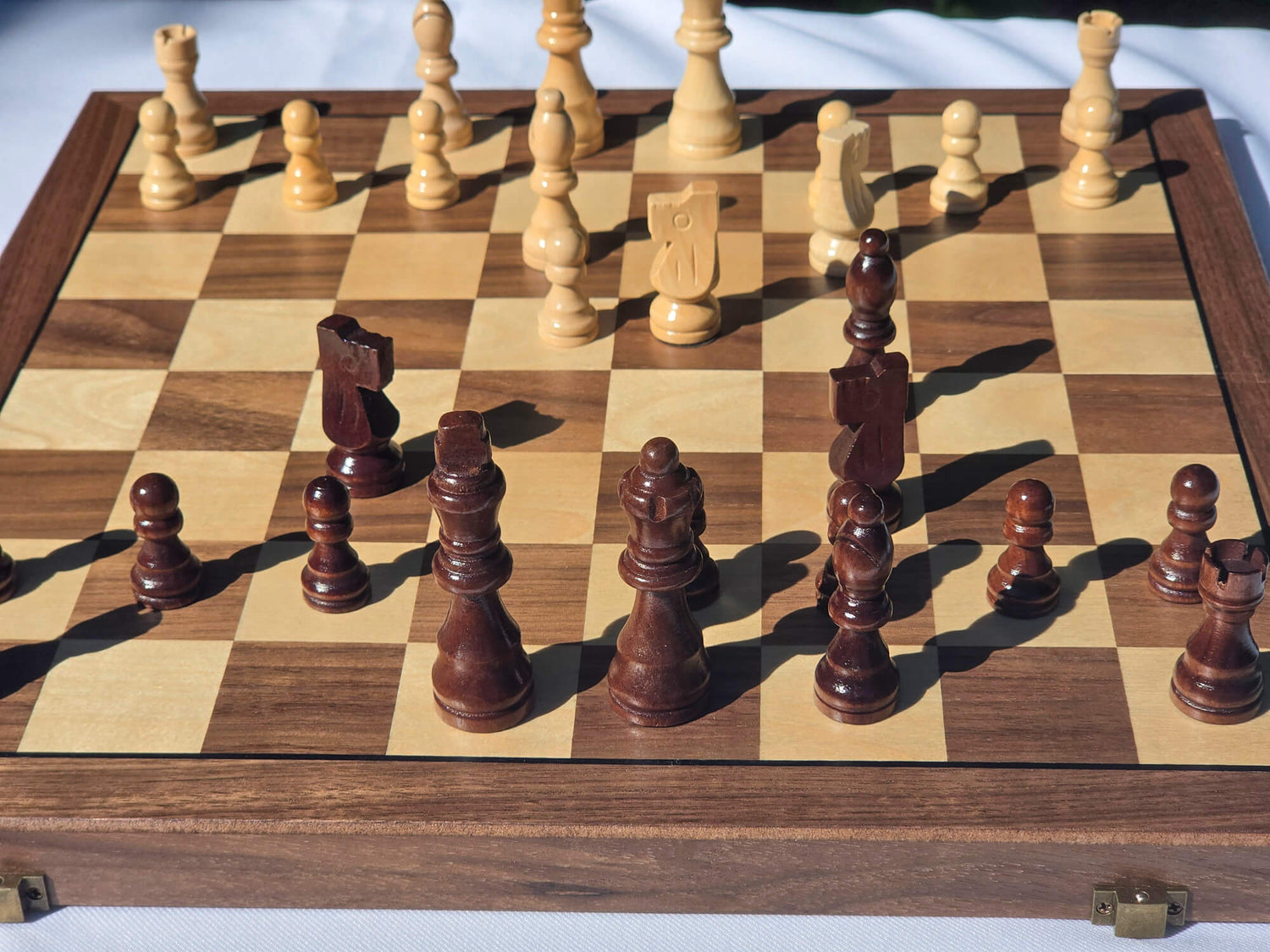 Focused iew of the Marquis Magnetic Walnut folding chess board set up with pieces in play.