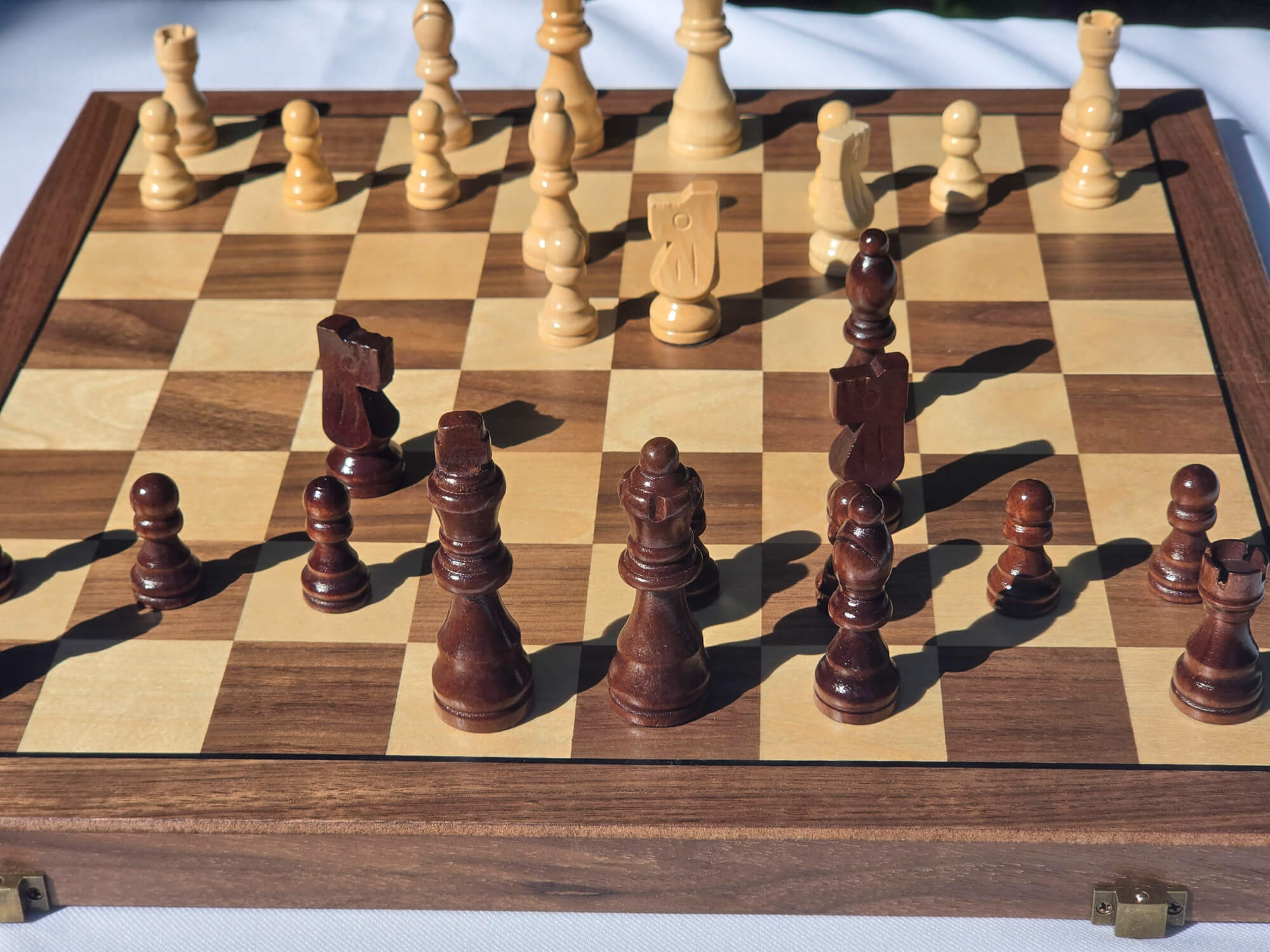 Focused iew of the Marquis Magnetic Walnut folding chess board set up with pieces in play.