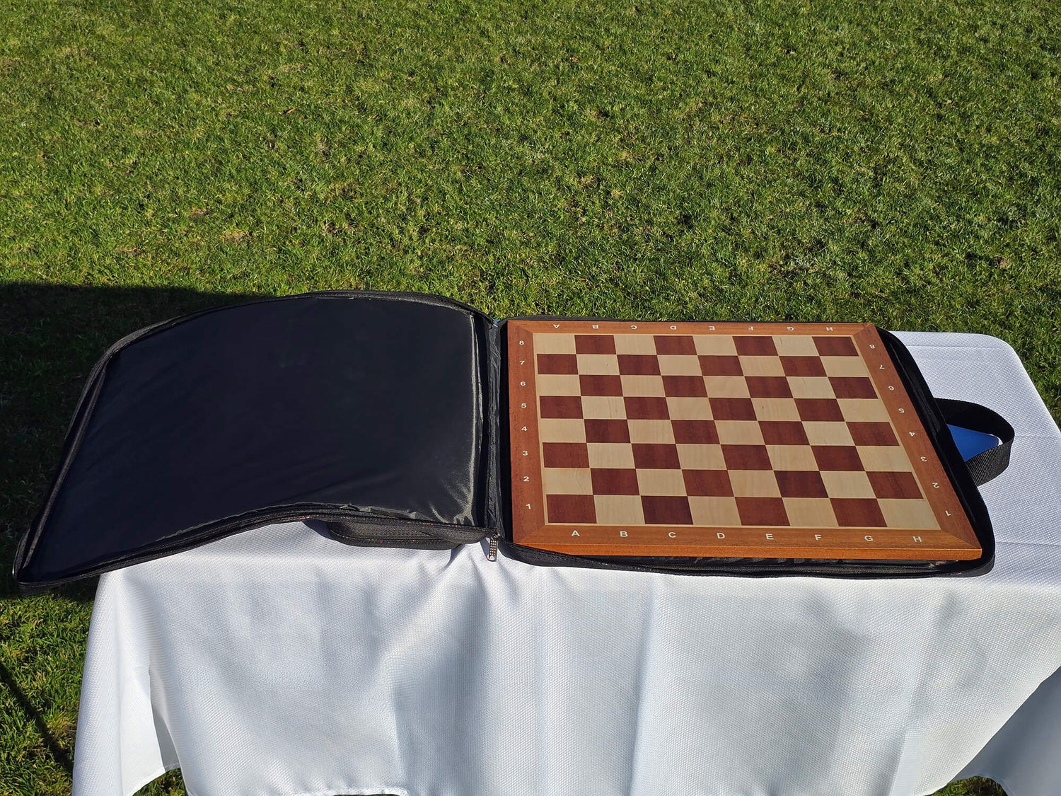 The Monarch padded carrying case with a full-sized wooden chess board tucked securely inside the main sleeve.
