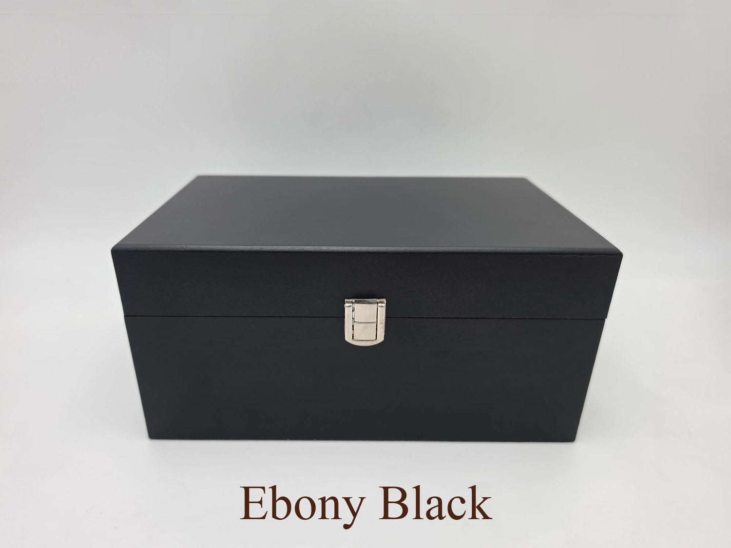 Front view of the closed Monarch ebony black wooden chess storage box featuring dark wood grain and with silver latch.
