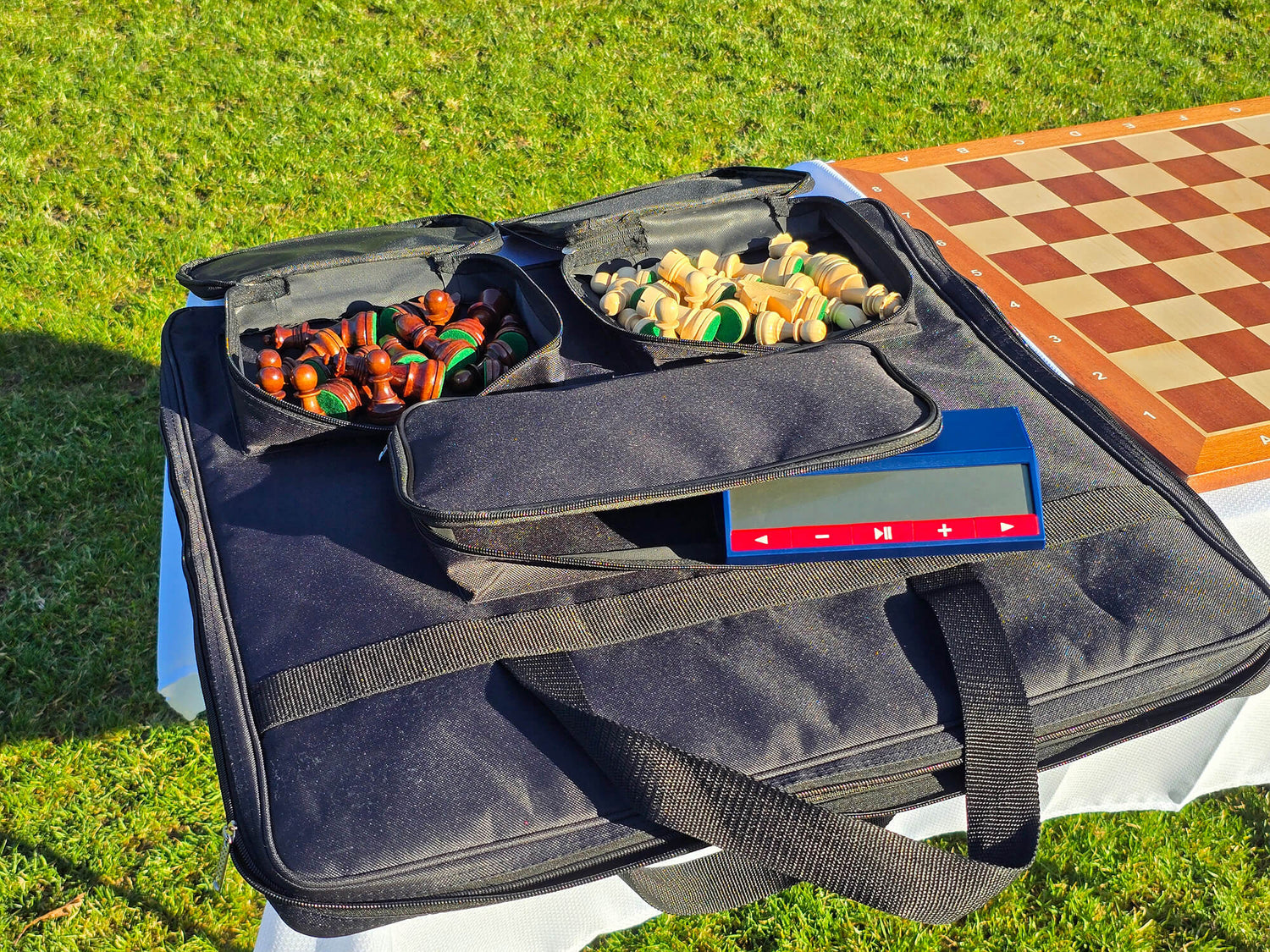 Open Monarch padded chess bag showcasing internal compartments for pieces and a dedicated chess clock slot.