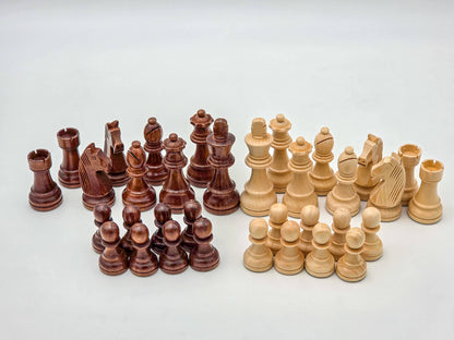 Studio shot showcasing a full 34-piece set of light and dark Germanic-style wooden chess pieces, neatly arranged in a lightbox.