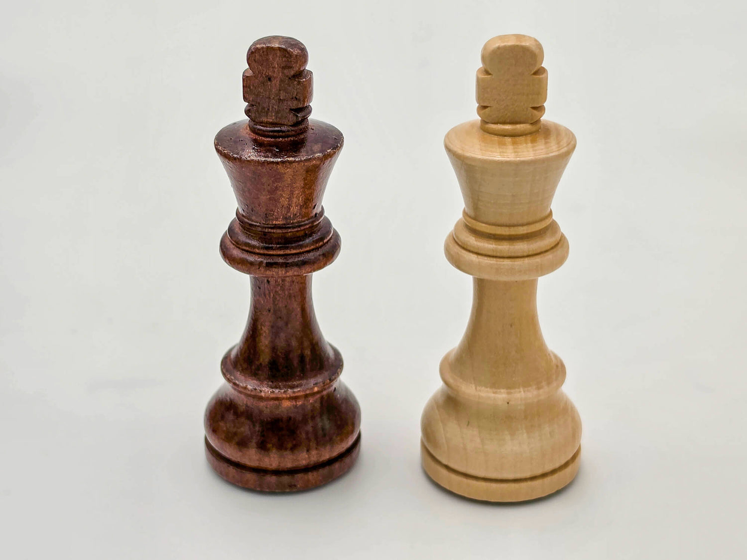 Side profile of the intricately carved Germanic light and dark wood chess kings, part of the Monarch Series.