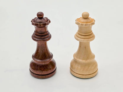 Detailed shot of the light and dark wood Germanic chess queens, part of the Monarch luxury collection.