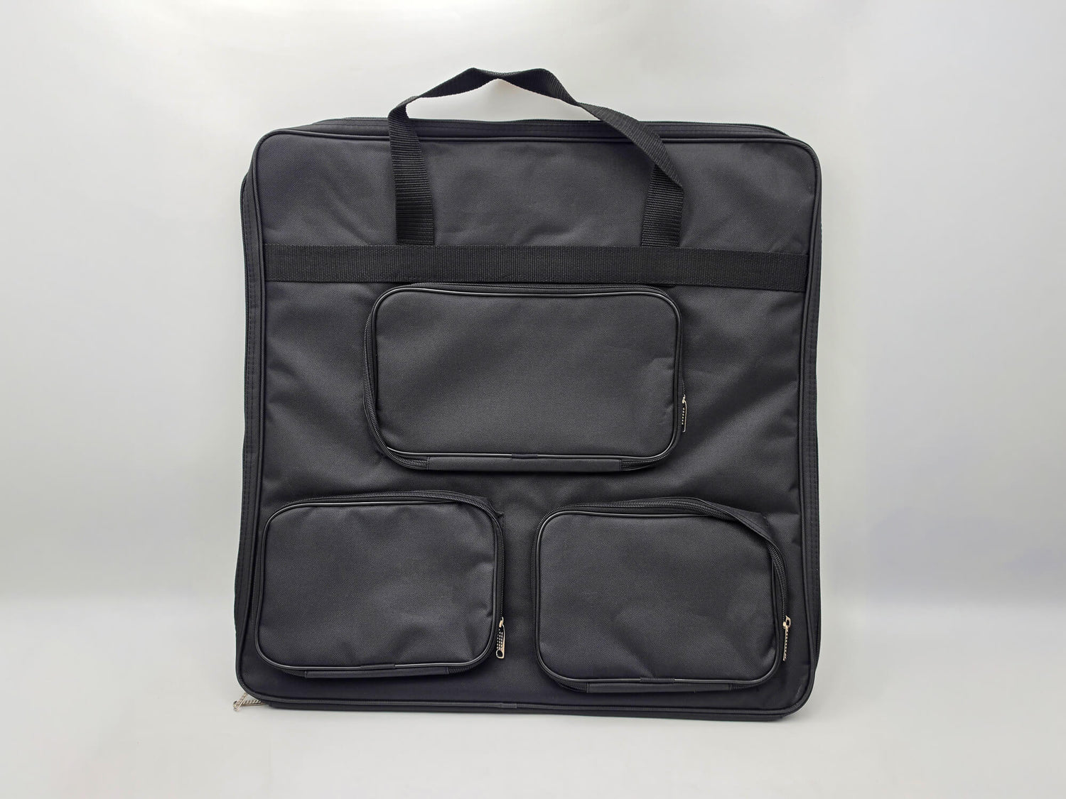 Large black padded carrying bag for the Monarch wooden chess set featuring three external zippered pockets for a chess clock and pieces.
