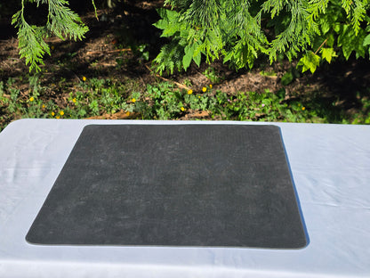 The textured, black non-slip rubber backing of a mousepad chess board displayed flat on a white surface.