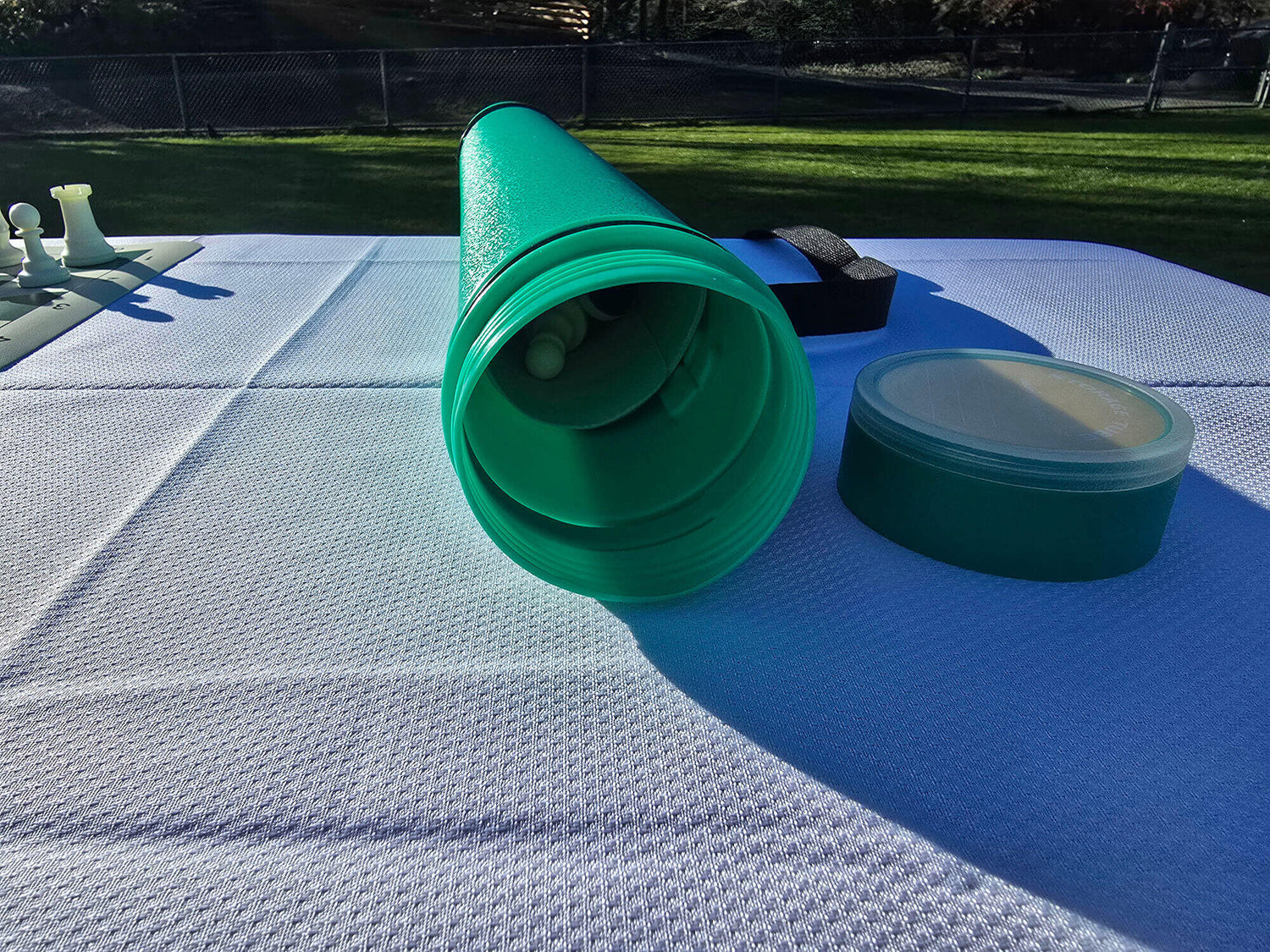Open green Sentry chess tube with the lid off, showing the interior storage for a roll-up board.