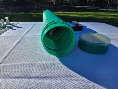 Open green Sentry chess tube with the lid off, showing the interior storage for a roll-up board.