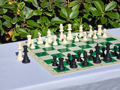 Perspective angle shot of silicone chess pieces set up on a flexible double-sided board against outdoor foliage.