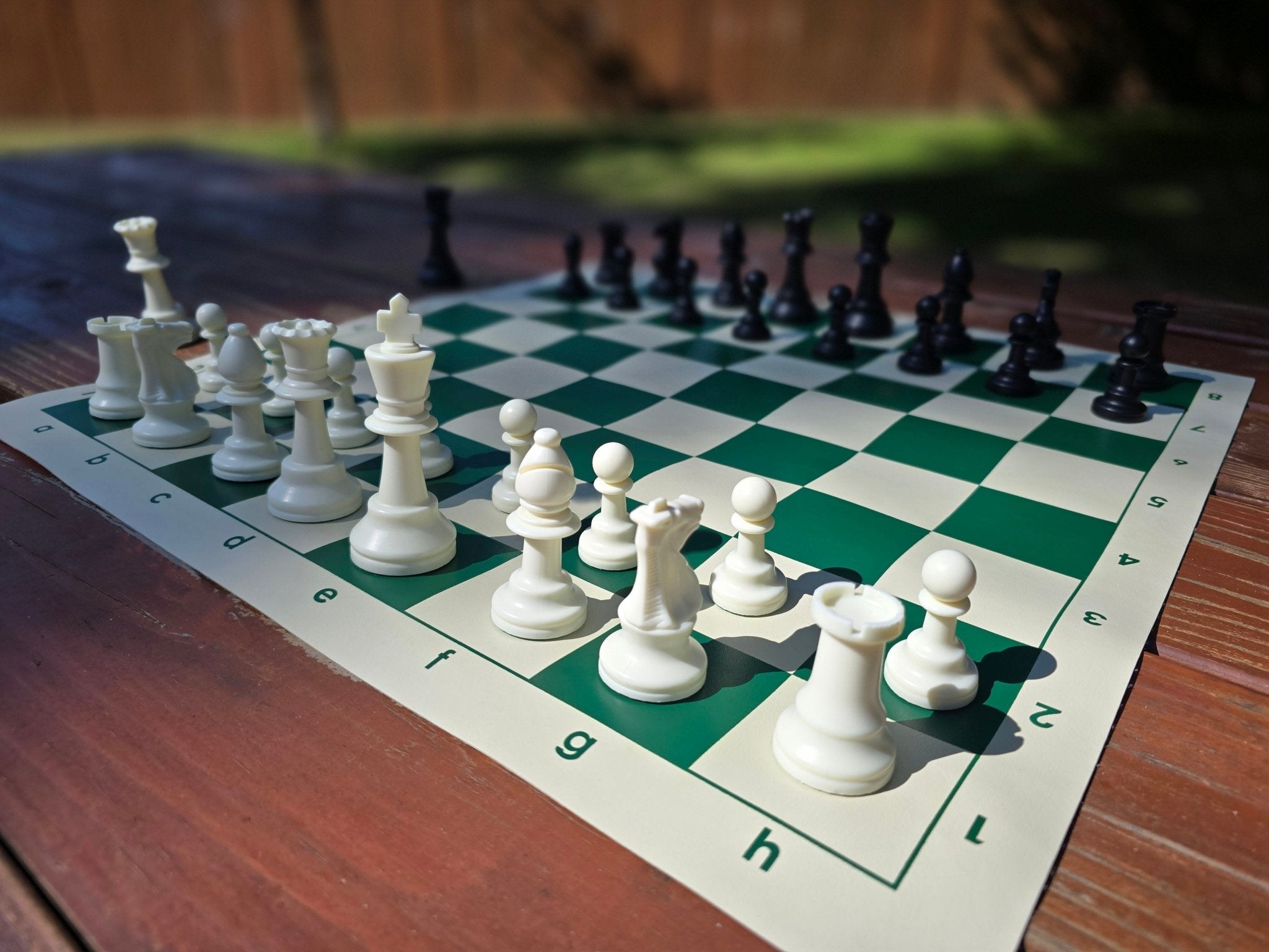 Tournament Chess Set on a Vinyl Chess Board on a Dark Brown Park Bench in Starting Position from White&