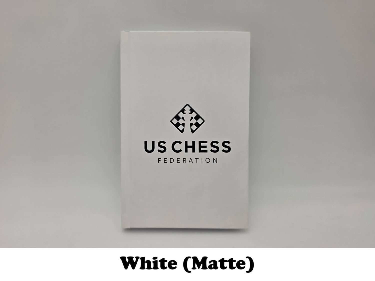 Clean white matte USCF chess notation scorebook.