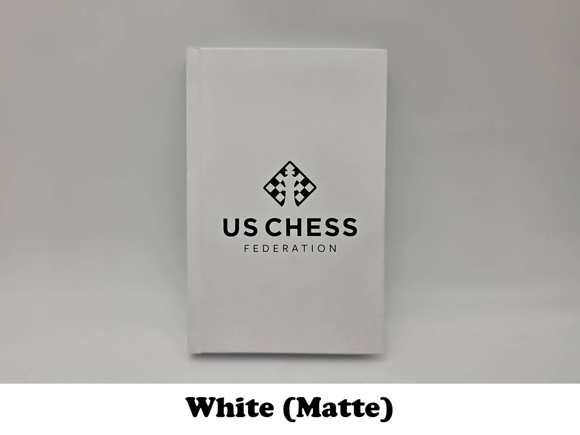 Clean white matte USCF chess notation scorebook.