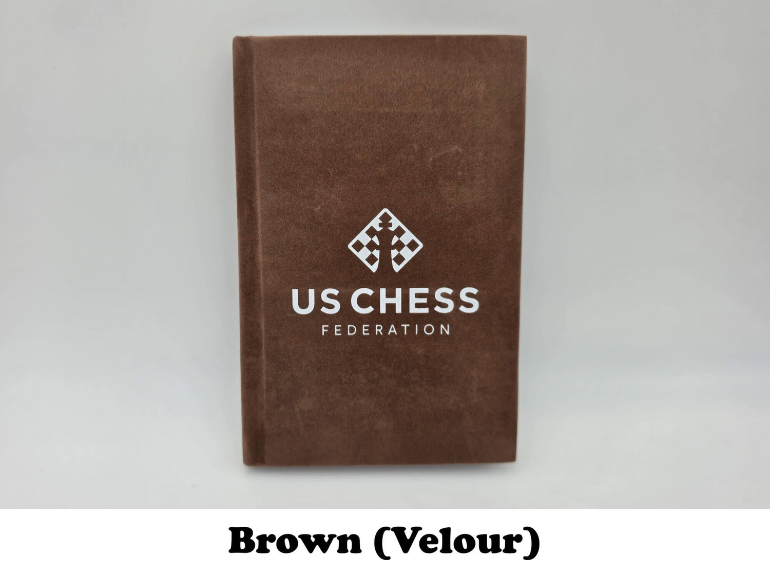 Soft brown velour USCF chess scorebook cover with official logo stamp.